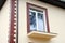 A new window in a new house. Unfinished balcony. Decorative plaster. Decorative tiles. Urban house or building, facade pattern. Ra