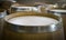 New wine barrels lined up in a warehouse, view of tops of barrels