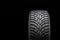 New winter studded tire, safety and premium quality. black background, close-up