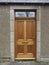 A new wooden Front Door with Brass Fittings set into an Old railway Cottage in the Village of Colliston.