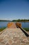 A new wooden jetty on the calm waters of a lake on a sunny summer day. Clear blue skies and calm weather