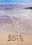 New Year 2015 is coming concept - inscription 2014 and 2015 on a beach sand, the wave is covering 2014