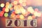 New year 2016 formed on wooden blocks and defocused bokeh Christmas lights background
