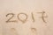 New Year 2017 is coming concept - inscription 2017 on a beach sand