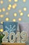 New Year 2019. Gingerbread figures on a wooden board. Christmas lights on the background. New Year greetings. Suitable as a backg