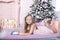 New Year 2020! The concept of Christmas, holidays and childhood. Cute baby girl writes a letter to Santa Claus near the Christmas