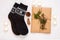 New year 2021 flat lay. Black ornamental socks, gift box in eco kraft paper with pine tree cones. Zero waste Christmas