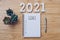 New year 2021 goals list. Office desk table with notebooks and pancil with pot plant