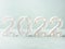 New year 2022 lights numbers on turquoise background. Holiday greeting