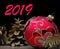 New Year background. New Year`s ball, branches of the Christmas tree and golden fir cones on a wooden table.