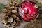 New Year background. New Year`s ball, branches of the Christmas tree and golden fir cones on a wooden table.