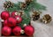 New Year background. New Year`s ball, branches of the Christmas tree and golden fir cones on a wooden table.