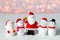 New year background with toy snowmen and Santa standing and smiling on a blurry background