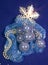 New Year balls which are poured violet on festive fabric with gold snowflakes and pearl jewelry on a blue background