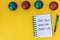 New year, better me. Happy new year quote. Writing in a notebook New year, better me on yellow background with Christmas balls.