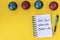 New year, better me. Happy new year quote. Writing in a notebook New year, better me on yellow background with Christmas balls.