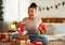 New Year celebration. Excited african american lady receiving xmas present and holding Christmas socks, sitting on bed