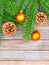 New Year or Christmas background: fir branches, goldish glass balls cones over old wooden backdrop