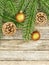 New Year or Christmas background: fir branches, goldish glass balls cones over old wooden backdrop, top view