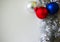 New Year Christmas background. Silver tinsel and three multicolored baubles. Holiday decorating concept