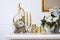 New Year and Christmas composition. Decorative golden clock, thick candles, candlestick, pot of flowers and framed canvas that han