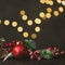 New Year and Christmas decoration, holiday background. Red festive ball bauble, green fir xmas tree and yellow blurred lights.