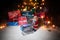 New year or Christmas holiday shopping concept. Store promotions. Santa Claus carrying trolley cart on snow. Stack of gift boxes