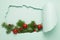 New Year or Christmas layout big hole paper background mint color. Christmas tree branch toys a blue bright background