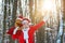 New year concept. Grandfather Santa walks in forest. Real Santa Claus in red cap pulling large red gift sack. Santa