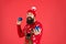 New year concept. Hipster bearded man wear winter sweater and hat hold balls red background. Christmas party. Winter