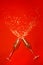 New Year Concept, star-shaped confetti spilling out of champagne glasses on a red background