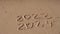 New Year concept. Text 2023 2024 handwritten in sand surface. Blue ocean wave washing away numbers at the beach