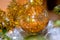 New year decor, tinsel. Glass ball toy with golden stars, orange garland