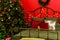 New Year decorated bedroom. Spacious red  bedroom with decorated Christmas tree and Christmas wreath on wall. Xmas in the evening