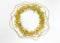 New year decorations of round circle yellow tinsel, golden bumps, chain of balls on a white background. Christmas