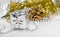 New year decorations - silver little gift, shiny golden tinsel, yellow toys, beads on white backdrop. Christmas