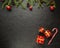 New Year. Fir branch, gift, caramel cane, cones, balls, beads. Christmas decorations on a dark background.