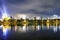 New Year fireworks over a city, night view to the illuminated sky. Streaks of light  upon the lake. Gniezno