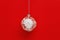 New Year glass ball transparent with white lace snowflake on red paper background