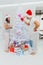 New year guy and girl decorate Christmas tree. Couple in love in santa hat, family