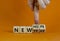 New year and hope symbol. Businessman turns cubes and changes the words `new year` to `new hope`. Beautiful orange background.