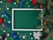 New year horizontal background - pine branches lie on a green background,photo frame surrounded by Christmas toys .Space for text.