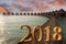 New Year inscription 2018 on the wooden road over the sea