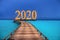 New Year inscription 2020 on the wooden road over the sea, mixed media