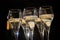 New year party, pouring of brut champagne bubbles cava or prosecco wine in tulip glasses with garland lights on background