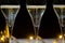 New year party, pouring of brut champagne bubbles cava or prosecco wine in tulip glasses with garland lights on background