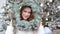 New year portrait of a woman smiling in a white sweater on the background of a Christmas tree