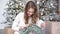 New year portrait of a woman smiling in a white sweater on the background of a Christmas tree