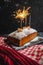 New year pound cake with Christmas spices and a bengal light sparkler. festive traditional bread on a black background