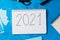 New Year resolution Goal list 2021 on blue background with notebook and chansellery